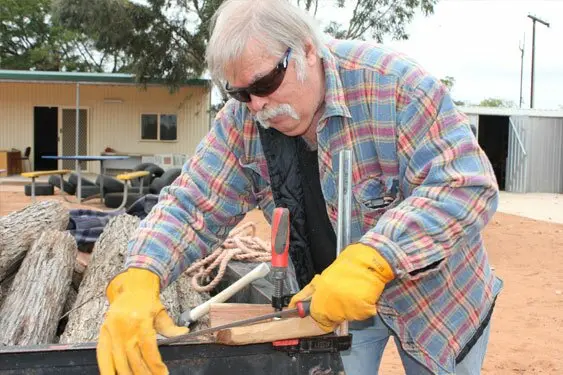 Darryl Thomas clamps his piece to the side of a trailer to get some traction with his rasp.