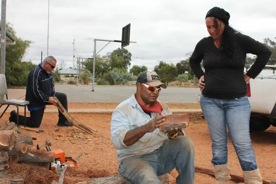 Lindsay works on a large boomerang while Patrick advises Kara Simes on a piti she is making.