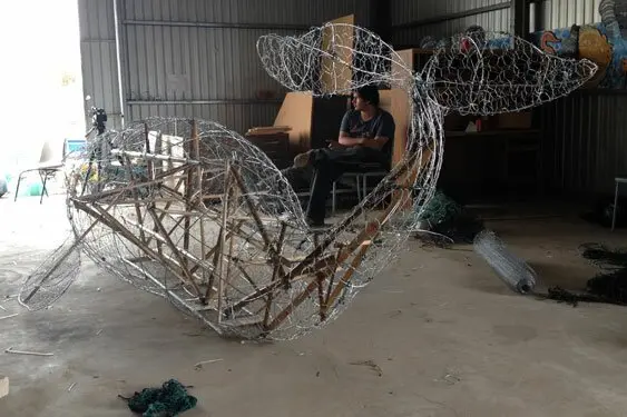 The Whale skeleton has been completed and tomorrow the skin will start to go on. This monster whale has been made to fit through the doors of the Art Space Gallery at the Adleaide Festival Centre where it will be shown at the Our Mob Exhibition from October 24. Ashley Sansbury relaxes in the background after a hard day in the chicken wire!